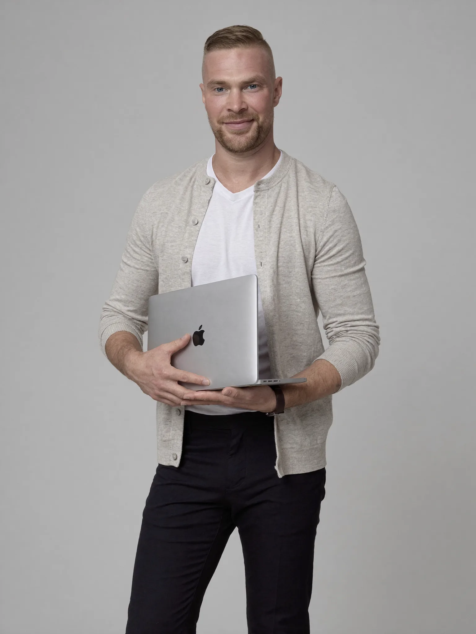 Alex Jego, fundador de JegoDigital, sosteniendo una MacBook